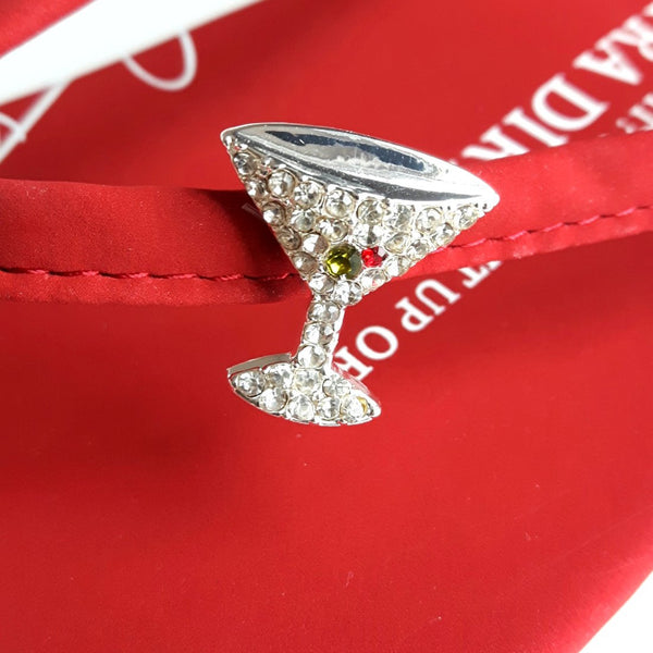Closeup of martini glass jewelry on designer red flip flops