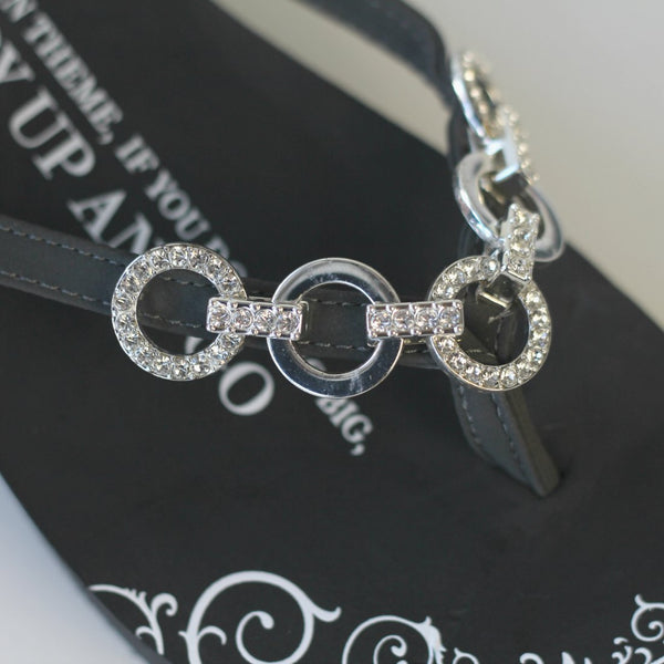 Closeup of jewelry on Five Link Circle gray platform flip flops 